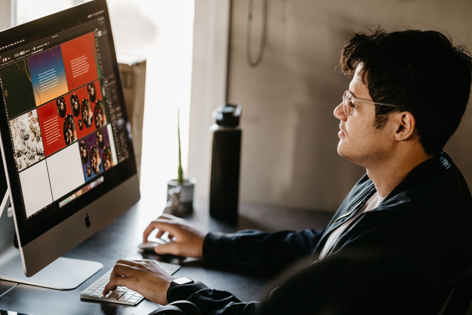 Creative professional reviewing a campaign layout on a large desktop screen