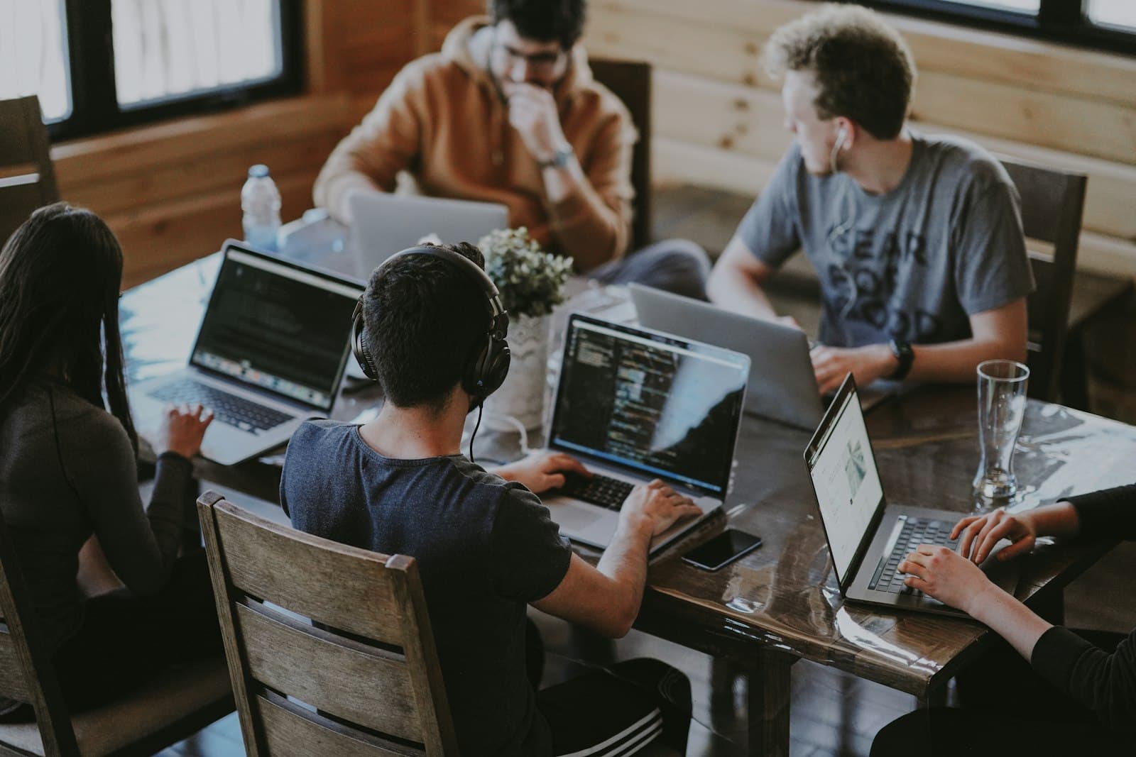 A stable squad of engineers collaborating around a table with laptops